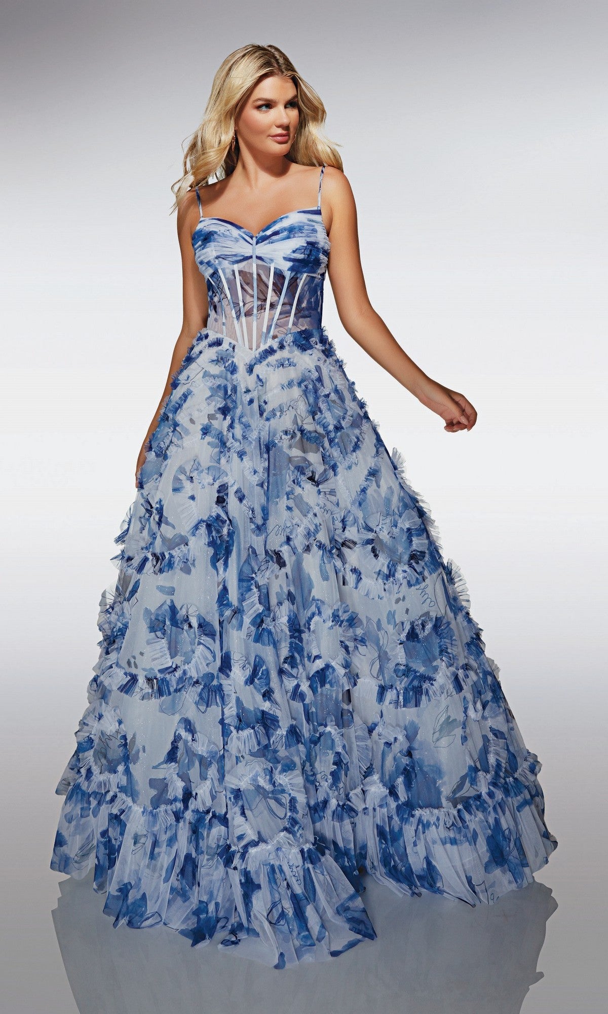 A woman wears the Alyce 62003 long prom dress, featuring blue and white hues, spaghetti straps, a sheer corset bodice, lace-up back, and a voluminous floral-appliquéd skirt.